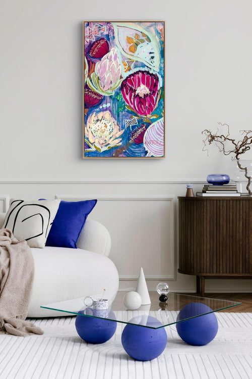 Modern living room with colorful abstract painting, glass coffee table, and decorative items.